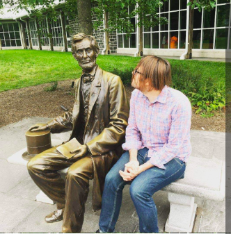 A man sitting next to a statue